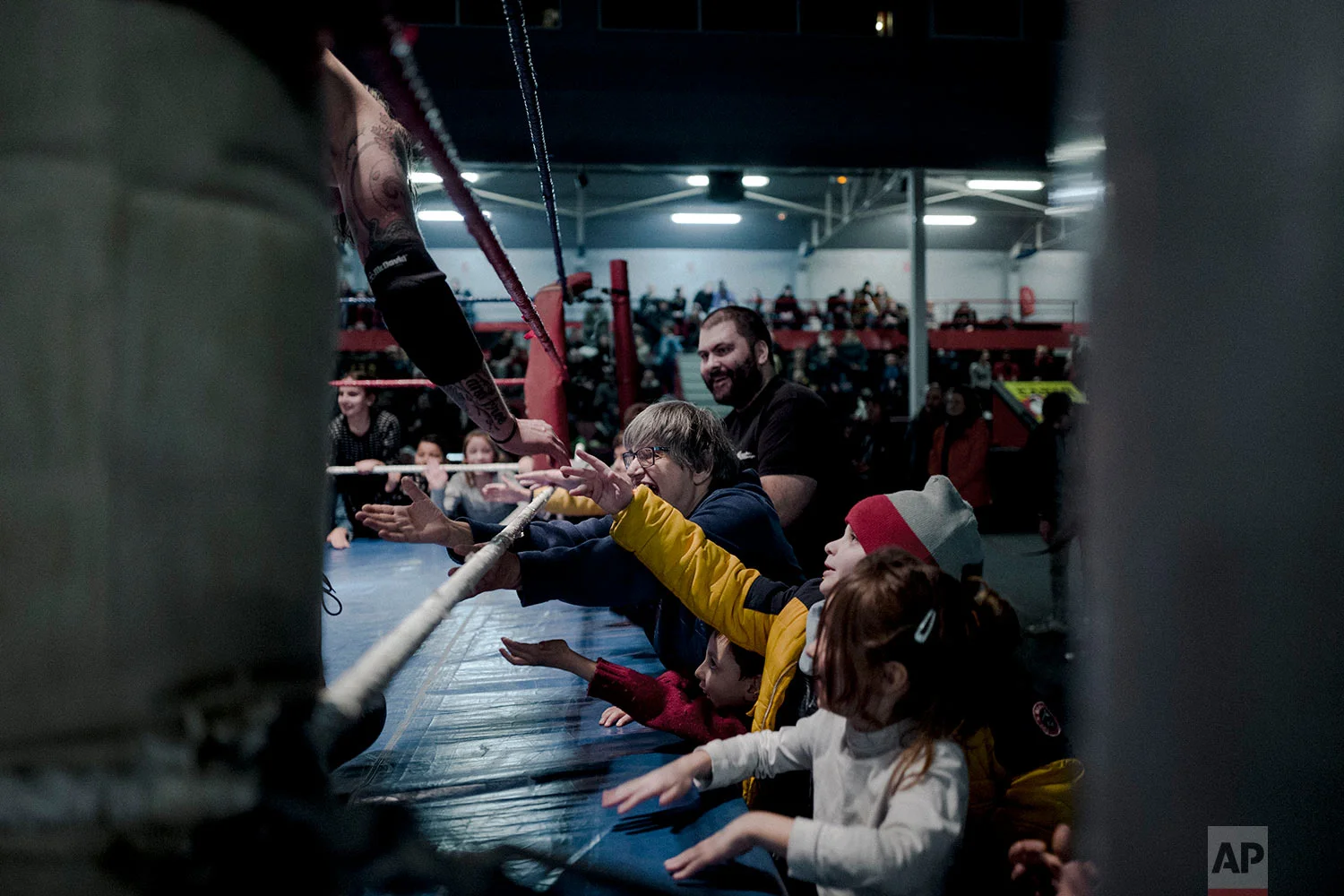  In this photo dated Saturday, Feb. 24, 2018, wrestler Zack claps hands with children during a wrestling charity gala in Ivry-sur-Seine, south of Paris, France.  (AP Photo/Kamil Zihnioglu) 