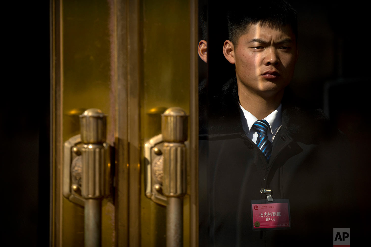  In this Thursday, March 8, 2018 photo, a security official stands guard at the doors of the Great Hall of the People during a plenary session of the Chinese People's Political Consultative Conference (CPPCC) in Beijing.   (AP Photo/Mark Schiefelbein