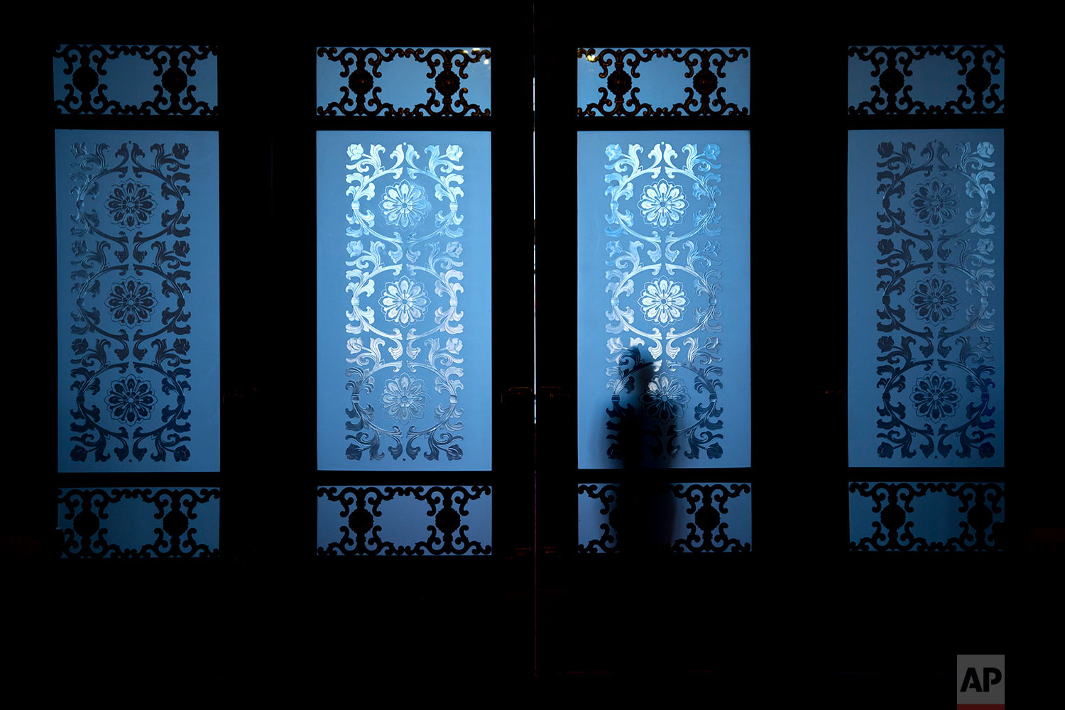  In this Friday, March 2, 2018 photo, a security official is silhouetted as he stands behind frosted glass doors at the Great Hall of the People in Beijing. (AP Photo/Mark Schiefelbein) 