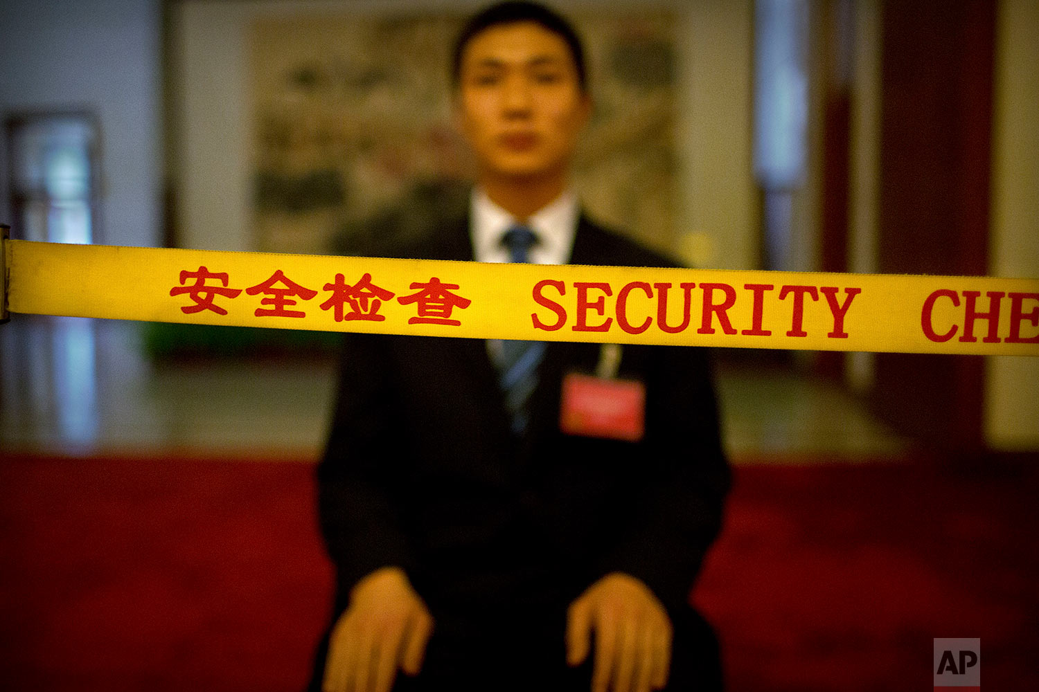  In this Friday, March 9, 2018 photo, a security official sits behind a rope line as he guards a corridor at the Great Hall of the People during a plenary session of China's National People's Congress (NPC) in Beijing. (AP Photo/Mark Schiefelbein) 