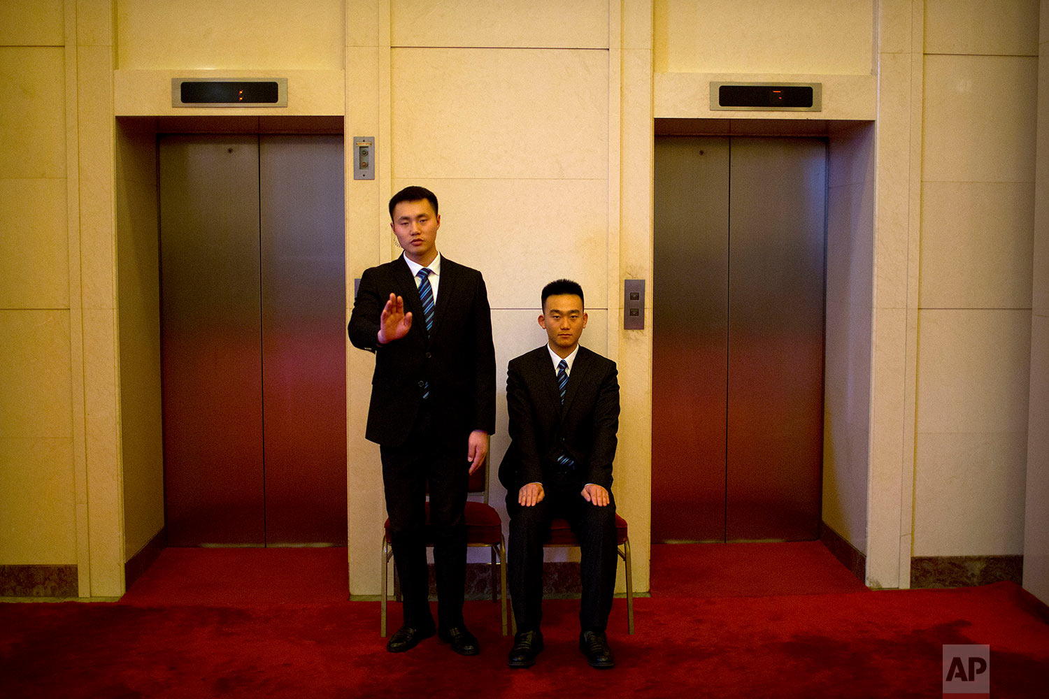  In this Tuesday, March 6, 2018 photo, security officials gesture as they stand guard at a bank of elevators at the Great Hall of the People in Beijing. (AP Photo/Mark Schiefelbein) 