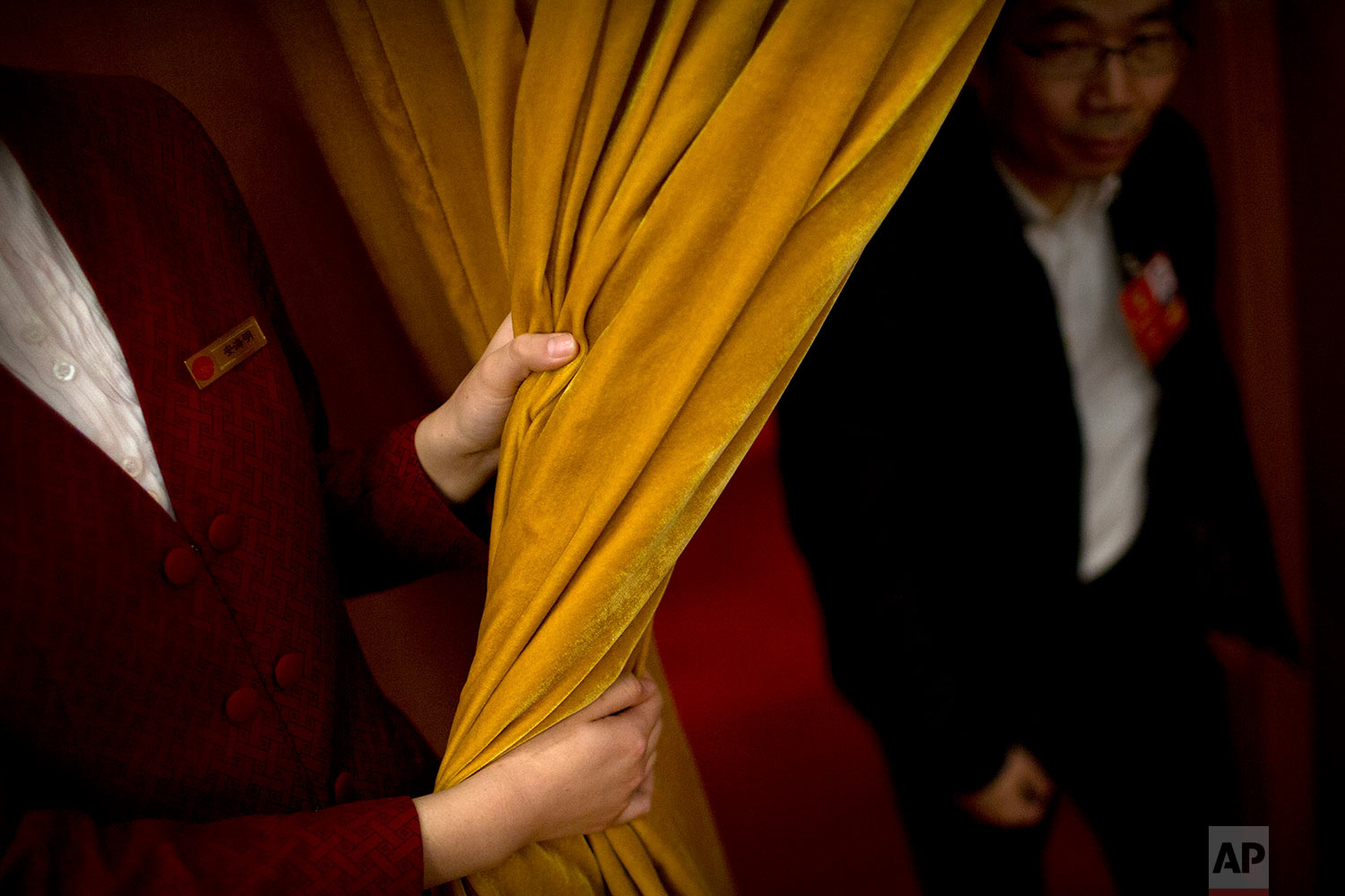  In this Friday, March 9, 2018 photo, an attendant pulls back a curtain for a delegate during a plenary session of China's National People's Congress (NPC) at the Great Hall of the People in Beijing. (AP Photo/Mark Schiefelbein) 