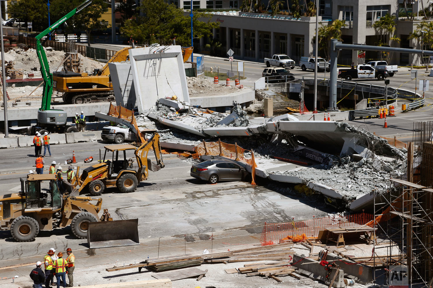  Crushed cars lie under a section of a collapsed pedestrian bridge near Florida International University in the Miami area on Friday, March 16, 2018. The bridge that was under construction collapsed onto a busy highway Thursday afternoon, crushing ve