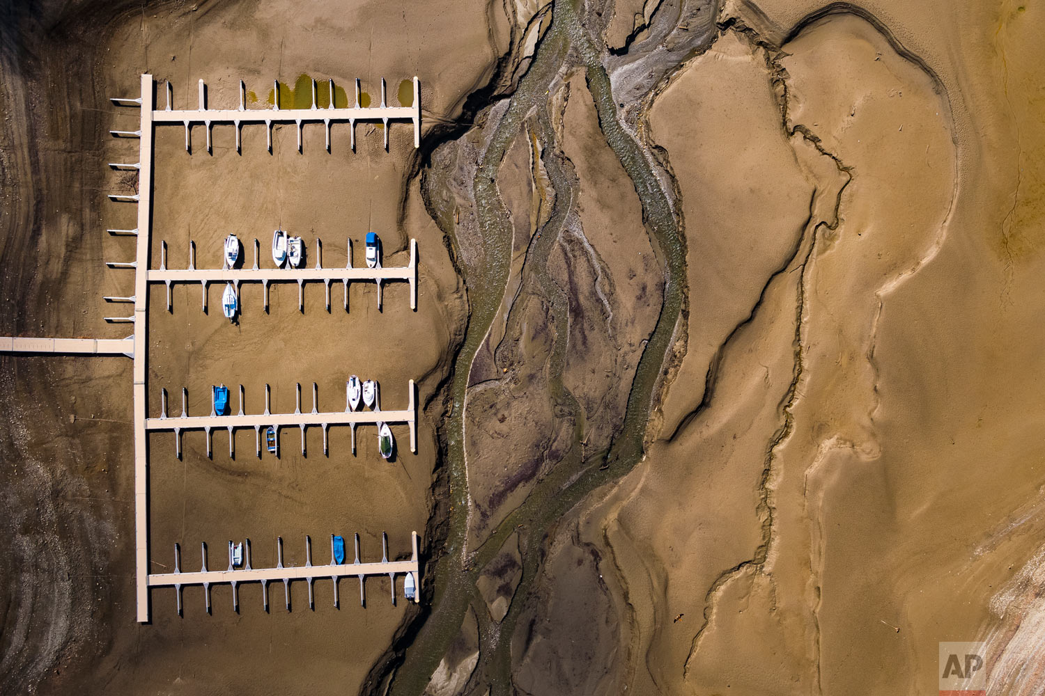  Stranded boats lie on the surface of the dried-out shores of the Lake of Gruyere in La Roche near Bulle, Switzerland, Wednesday, March 14, 2018. The level of the artificial impounding reservoir is progressively being reduced by 15 to 20 meters, in a