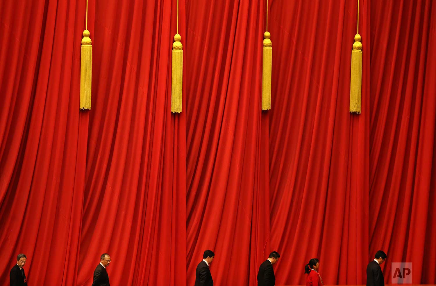  In this Thursday, March 15, 2018 photo, delegates walk past red curtains as they leave after attending the closing session of the Chinese People's Political Consultative Conference (CPPCC) at the Great Hall of the People in Beijing. (AP Photo/Aijaz 