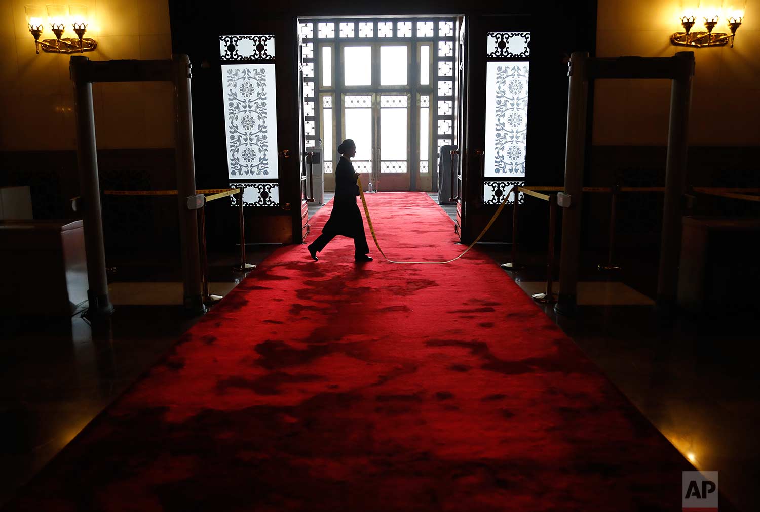  In this Tuesday, March 13, 2018 photo, a Chinese security staff walks on a red carpet at the entrance of the Great Hall of Beijing during a provincial group discussion meeting held during China's National People's Congress (NPC) in Beijing. (AP Phot