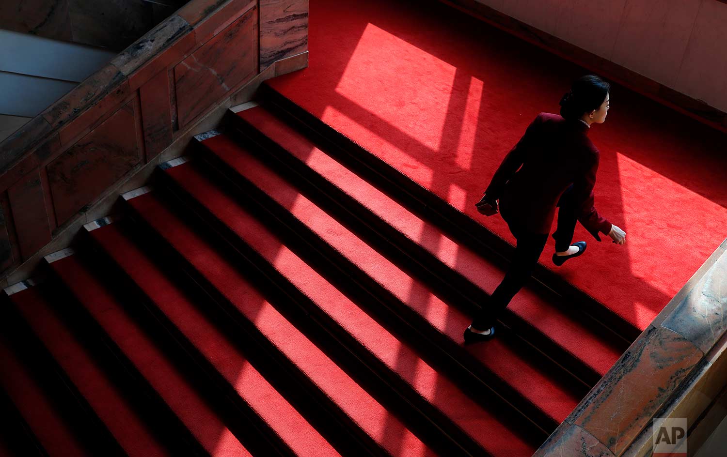  In this Tuesday, March 13, 2018 photo, an attendant climbs stairs covered with red carpet during a plenary session of China's National People's Congress (NPC) at the Great Hall of People in Beijing. (AP Photo/Aijaz Rahi) 