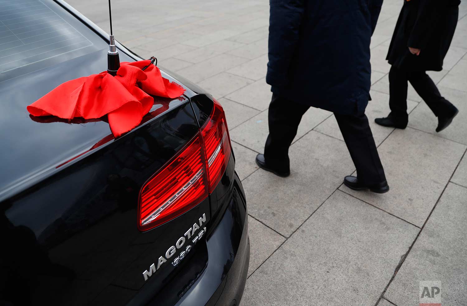  In this Thursday, March 15, 2018 photo, red ribbon is tied to an antenna of an escort car parked outside The Great Hall of People during the closing session of the Chinese People's Political Consultative Conference (CPPCC) at the Great Hall of the P