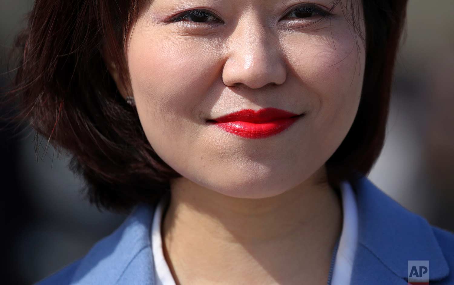  In this Thursday, March 15, 2018 photo, a staff member wears red lipstick as she leaves after the closing session of the Chinese People's Political Consultative Conference (CPPCC) at the Great Hall of the People in Beijing. (AP Photo/Aijaz Rahi) 