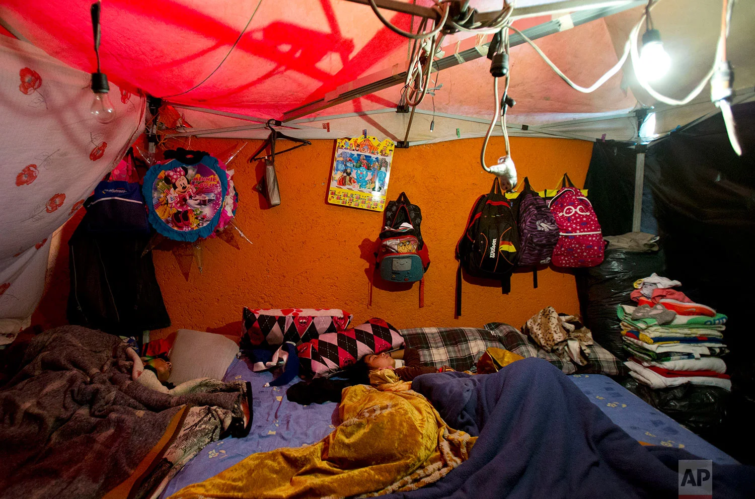 Children sleep in a shelter built against the external wall of a house, at a tent camp outside earthquake-damaged Independencia 18 in Mexico City, Jan. 5, 2018. (AP Photo/Rebecca Blackwell)