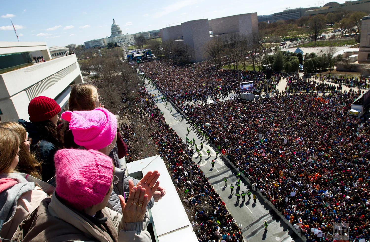 People on the balcony at the Newseum join with protesters on Pennsylvania Avenue as they look twoard the stage near the Capitol during the "March for Our Lives" rally in support of gun control in Washington, Saturday, March 24, 2018. (AP Photo/Jose Luis Magana)
