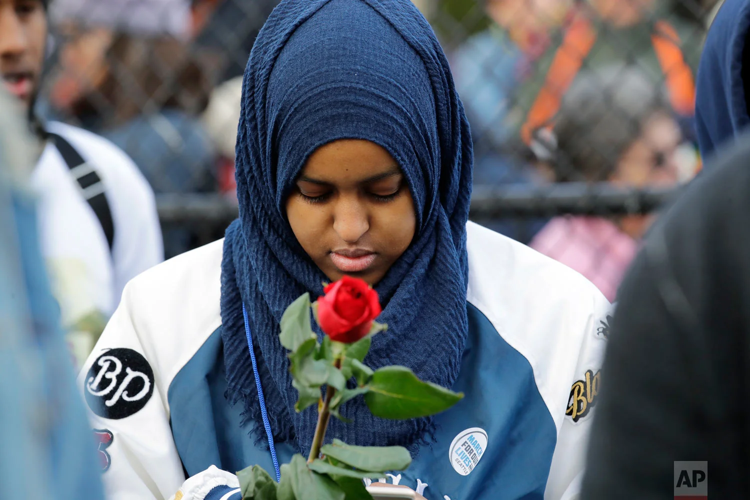 Naj Ali, a high school senior, holds a rose in memory of a person lost to gun violence during a rally before a march in favor of gun control Saturday, March 24, 2018, in Seattle. Summoned to action by student survivors from Marjory Stoneman Douglas High School in Parkland, Fla., hundreds of thousands of teenagers and their supporters rallied in the nation's capital and cities across the U.S. on Saturday to press for gun control. (AP Photo/Elaine Thompson)