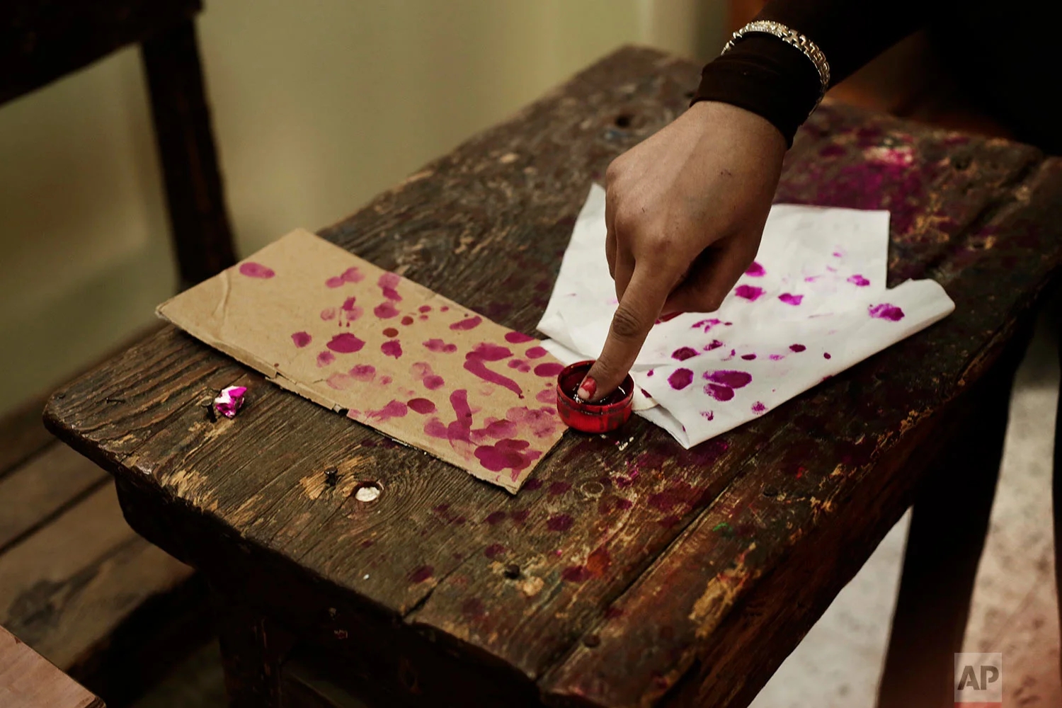 A woman inks her finger on the third day of the presidential election inside a polling station in the popular district of Shubra, Cairo, Egypt Wednesday, March 28, 2018. (AP Photo/Nariman El-Mofty)