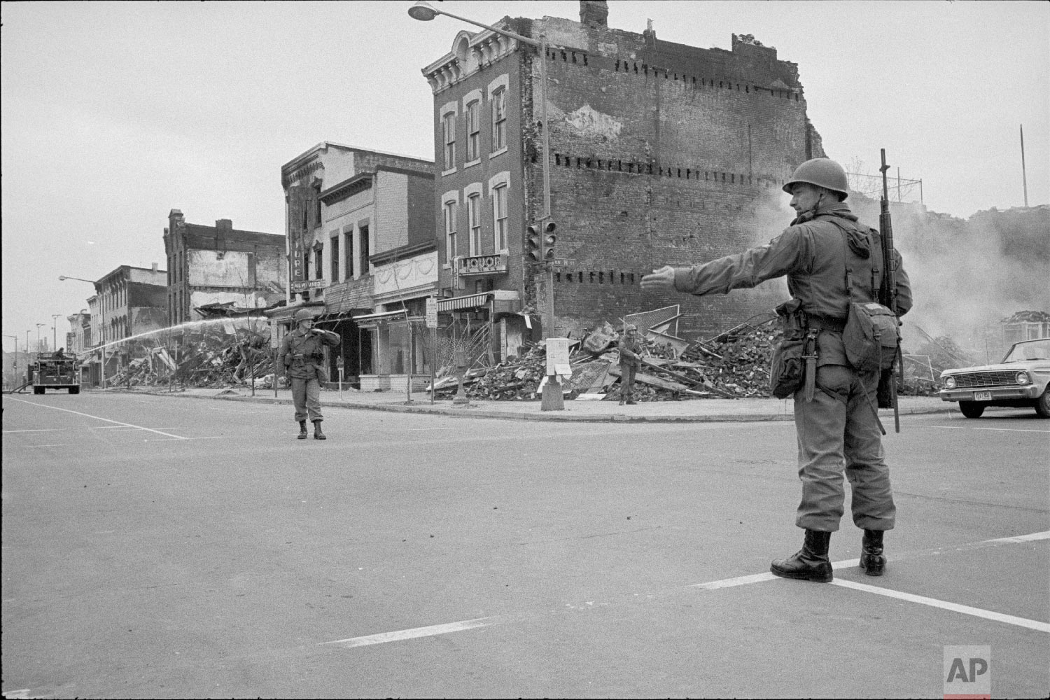  Photograph showing a soldier standing guard at 7th and N Street, N.W., Washington, D.C., Monday, April 8, 1968, with the ruins of buildings that were destroyed during the riots that followed the assassination of Martin Luther King, Jr. (Photo/ Warre