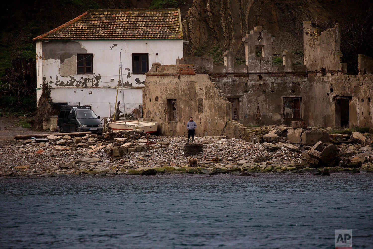 A man stands near the shore next to La Linea de la Conception in Cadiz province. (AP Photo/Emilio Morenatti)