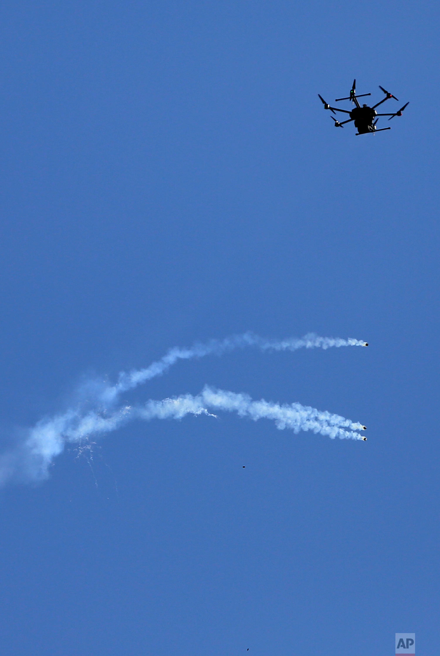 A drone used by Israeli troops fires teargas at Palestinians during a demonstration near the Gaza Strip border with Israel, in eastern Gaza City, Friday, March 30, 2018. (AP Photo/ Khalil Hamra)