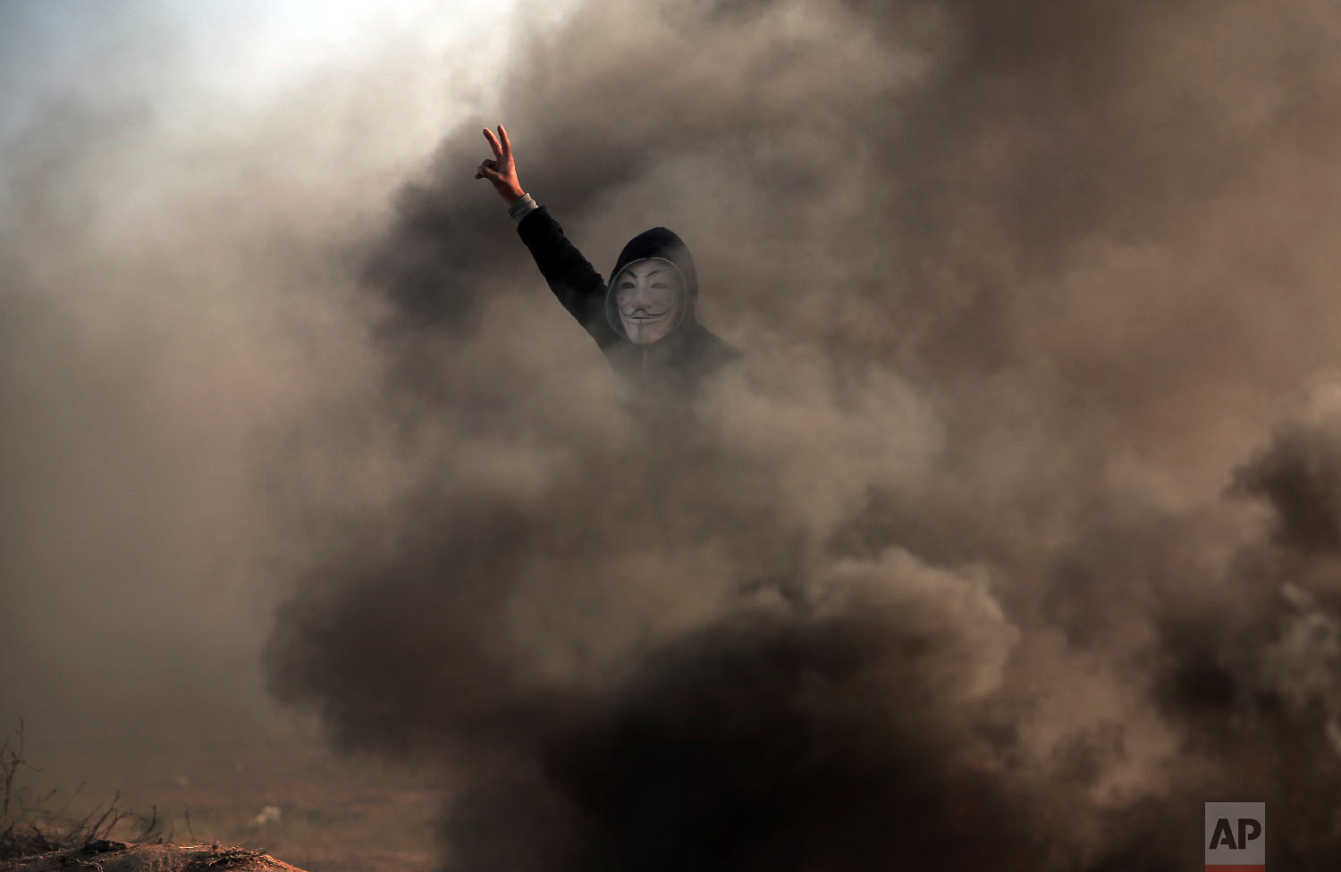  A Palestinian protester flashes the V sign during a protest near the Gaza Strip border with Israel, in eastern Gaza City, Saturday, March 31, 2018. (AP Photo/ Khalil Hamra) 