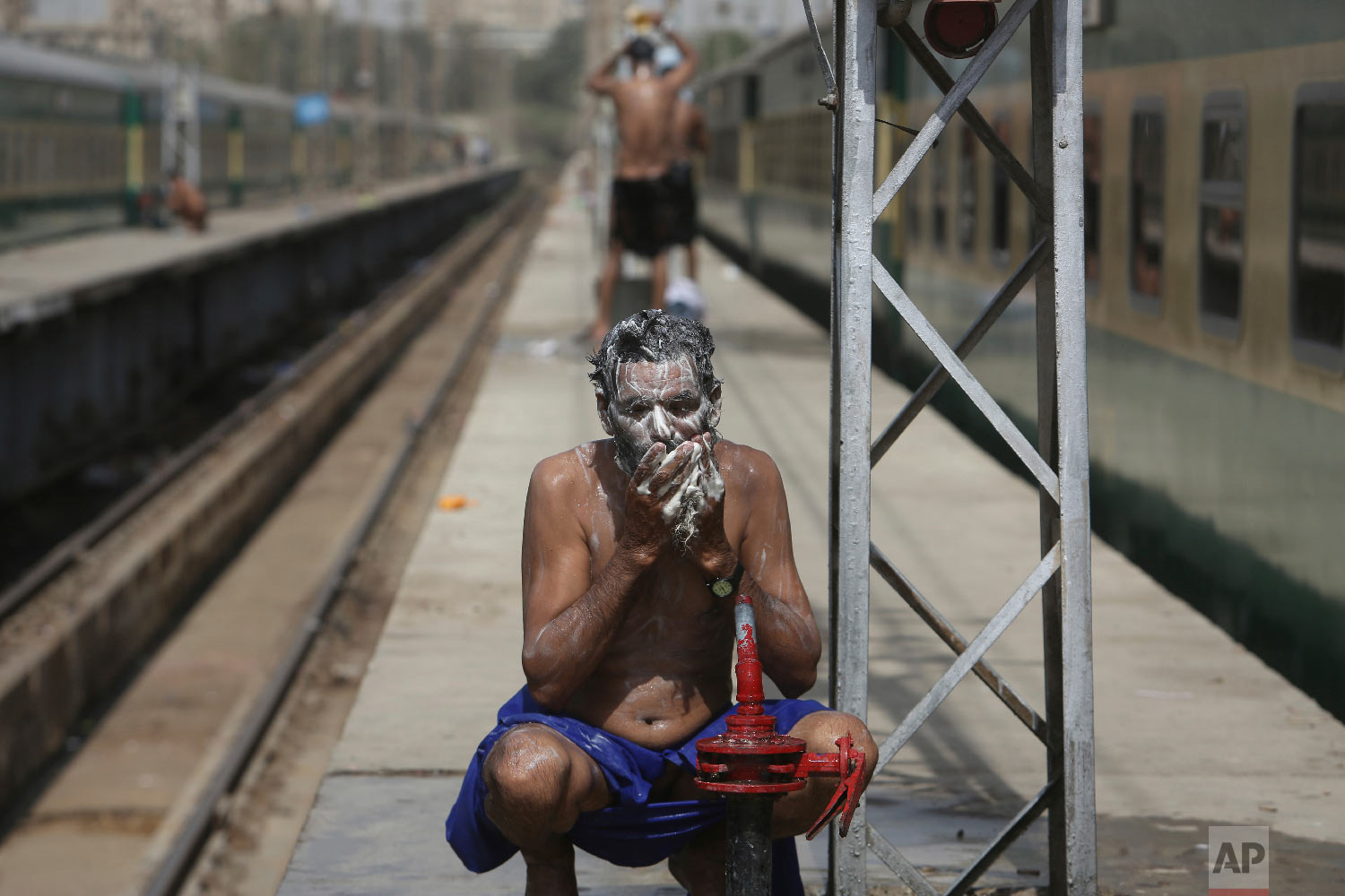 Pakistan railway employees cool themselves off during a hot afternoon in Karachi, Pakistan, Wednesday, March 28, 2018. People experience warm weather, with the temperatures reaching 39 degree Celsius (102 Fahrenheit). (AP Photo/Fareed Khan)