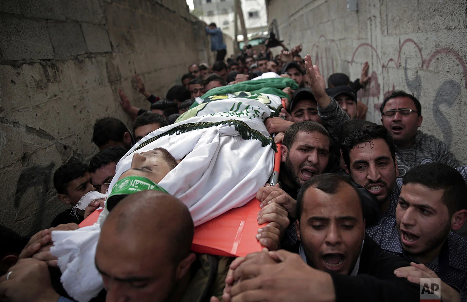 Palestinian mourners carry the body of 23-year-old Mojahid al-Khodari, who was killed early Thursday morning by an Israeli airstrike, during his funeral in Gaza City, Thursday, April 5, 2018. (AP Photo/Khalil Hamra)
