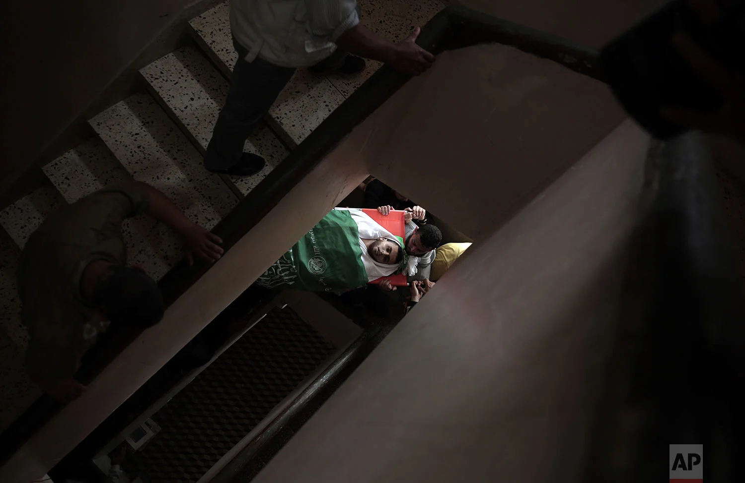 Palestinian mourners carry the body of 23-year-old Mojahid al-Khodari, who was killed early Thursday morning by an Israeli airstrike, mourn over his body in the family house during his funeral in Gaza City, Thursday, April 5, 2018. (AP Photo/Khalil Hamra)