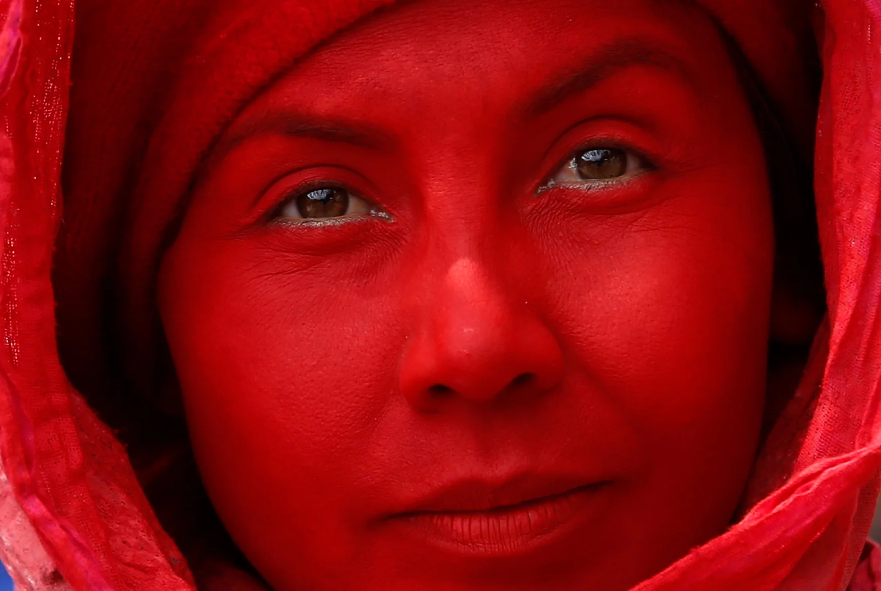 A Tecal theater group performer eyes the camera during the inaugural parade kicking off the 16th Ibero-American Theatre Festival, in Bogota, Colombia, Saturday, March 17, 2018. The 17-day festival celebrates the performing arts, including circus, cabaret, musicals, live bands and dance. (AP Photo/Fernando Vergara)