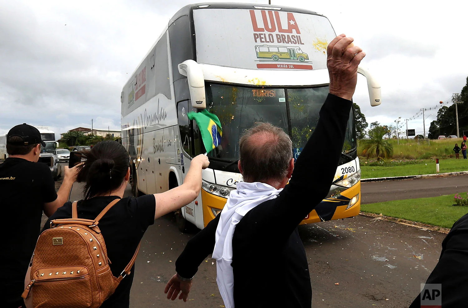 Opponents of Brazil's former President Luiz Inacio Lula da Silva throw eggs at his caravan arriving to Sao Miguel do Oeste in southern Brazil, March 25, 2018. The former leader is leading polls for October’s presidential election but is likely to be barred from running and judges could order him to begin serving his sentence on a corruption conviction. (AP Photo/Eraldo Peres)