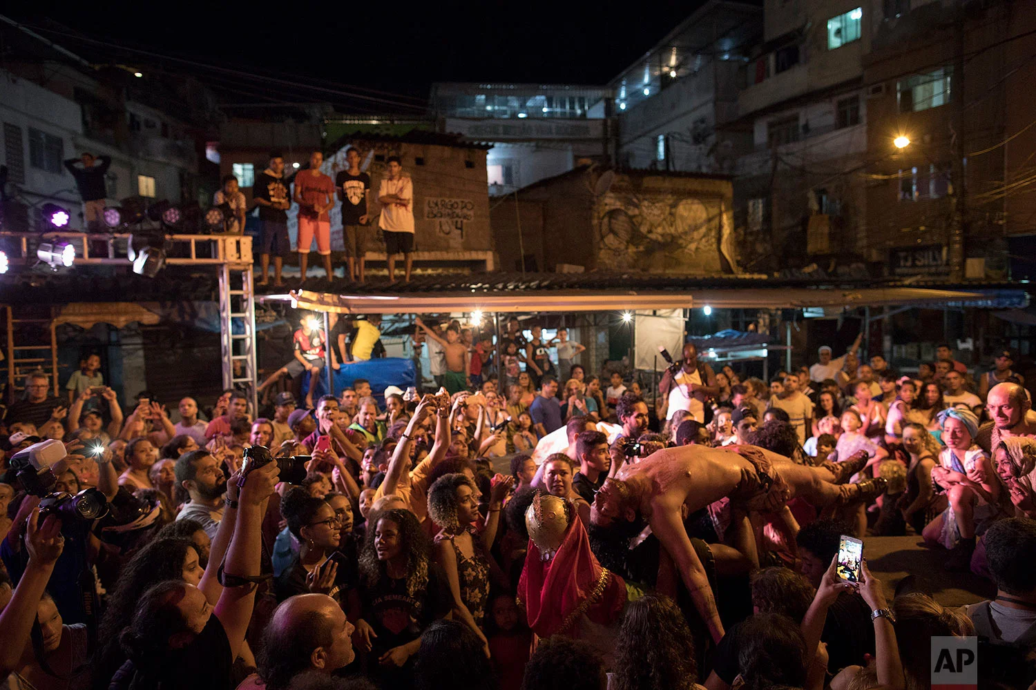 Carried by other actors, Jefferson Messias plays the role of Jesus during a Passion of Christ procession on Good Friday during Holy Week at the Rocinha slum in Rio de Janeiro, Brazil, March 30, 2018. This year the actors performed what they call The Social Crucifixion of the "Favelado" or slum's resident, in Portuguese, due to the last events of violence in Rocinha where there have been 12 victims of gun violence in the last two weeks, including a military police officer. (AP Photo/Leo Correa)