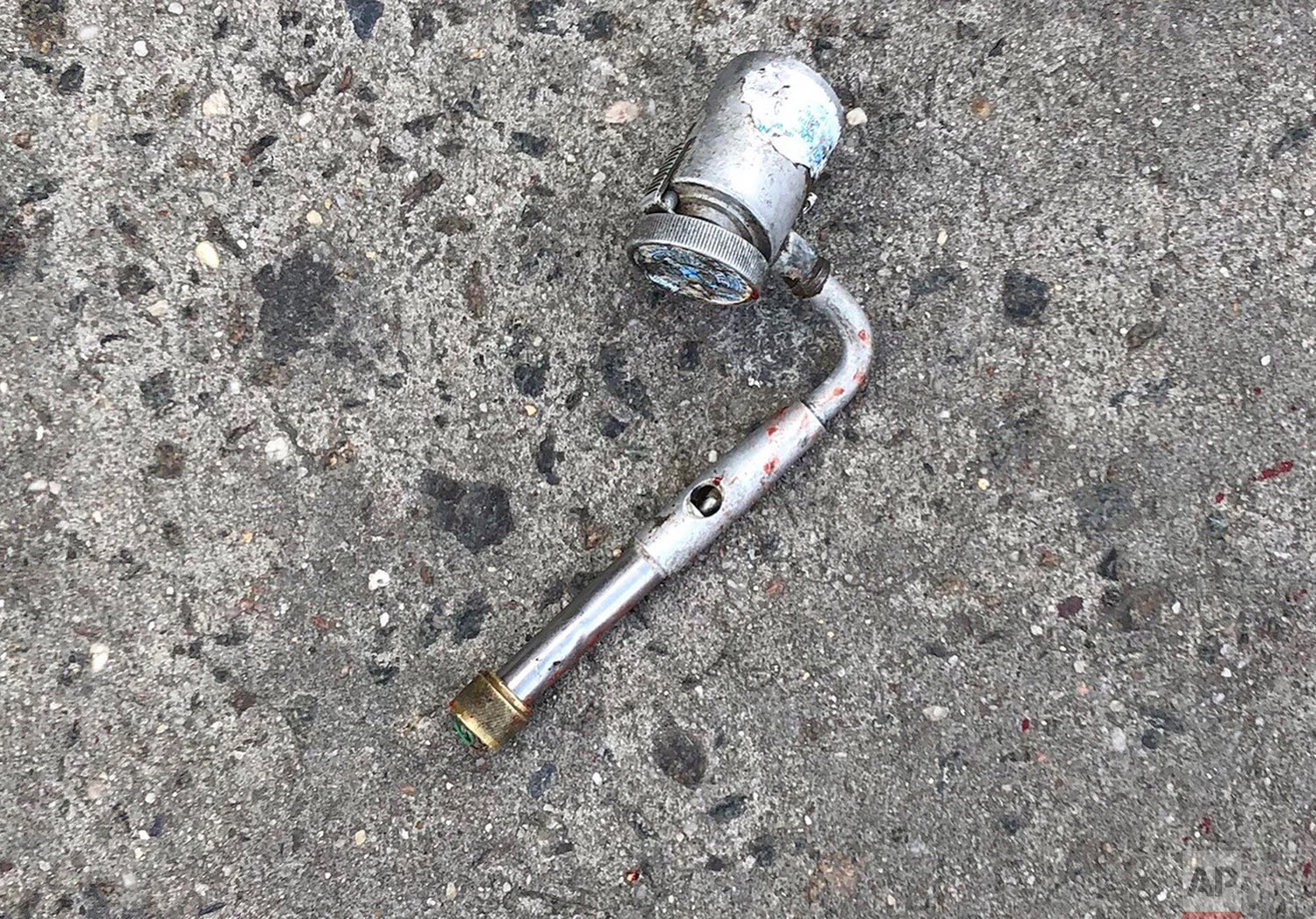 This photo provided by the New York Police Department shows a metal object at the scene where police officers fatally shot a man who was reported to be threatening people with a gun, which turned out to be a metal pipe that police mistook for a firearm, in the Brooklyn borough of New York. (New York Police Department via AP) 