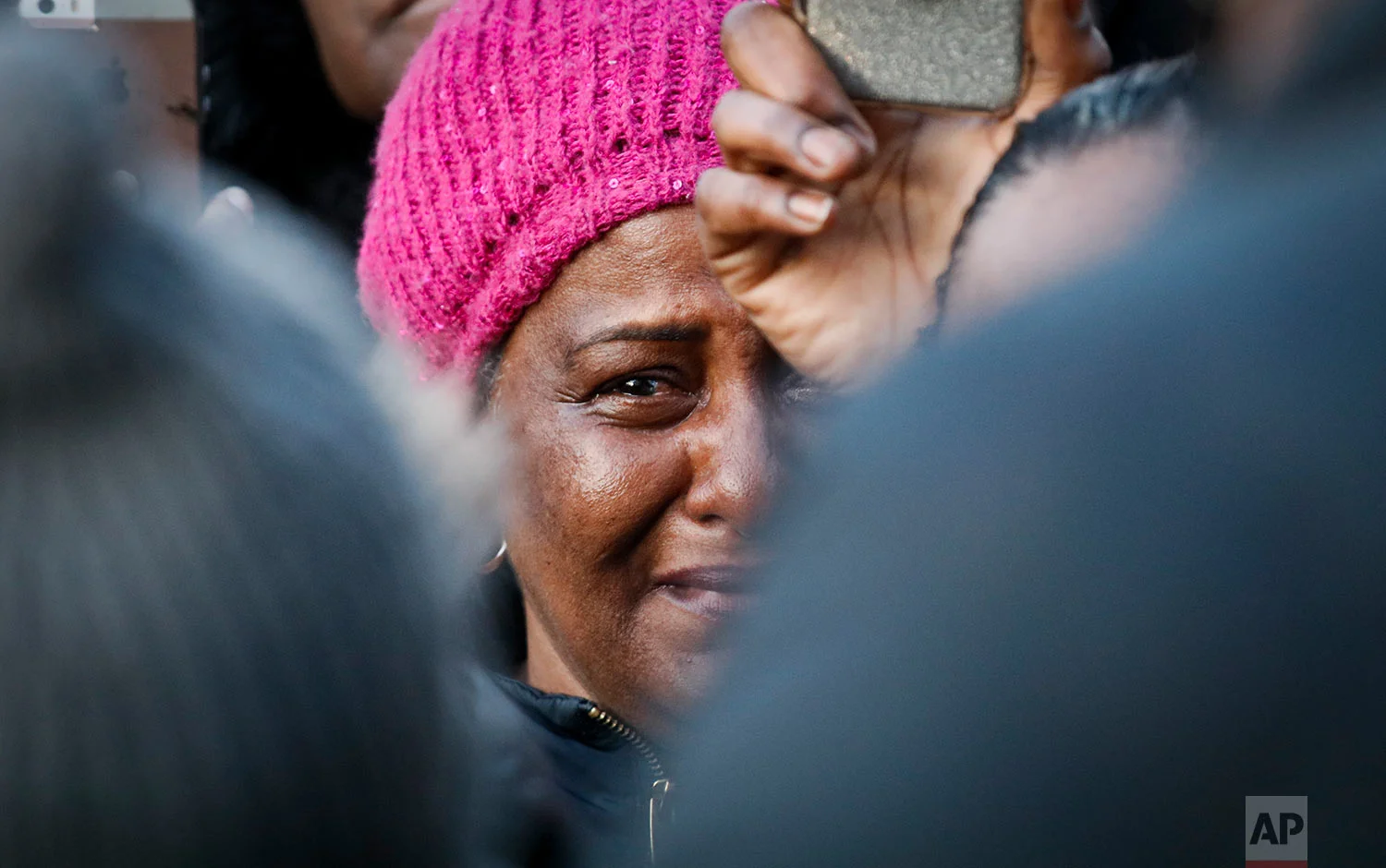 A woman cries as she listens to Lorna Vassell address a rally for son Saheed Vassell, fatally shot by police Wednesday, in the Crown Heights section of Brooklyn borough in New York on Thursday, April 5, 2018. (AP Photo/Bebeto Matthews)