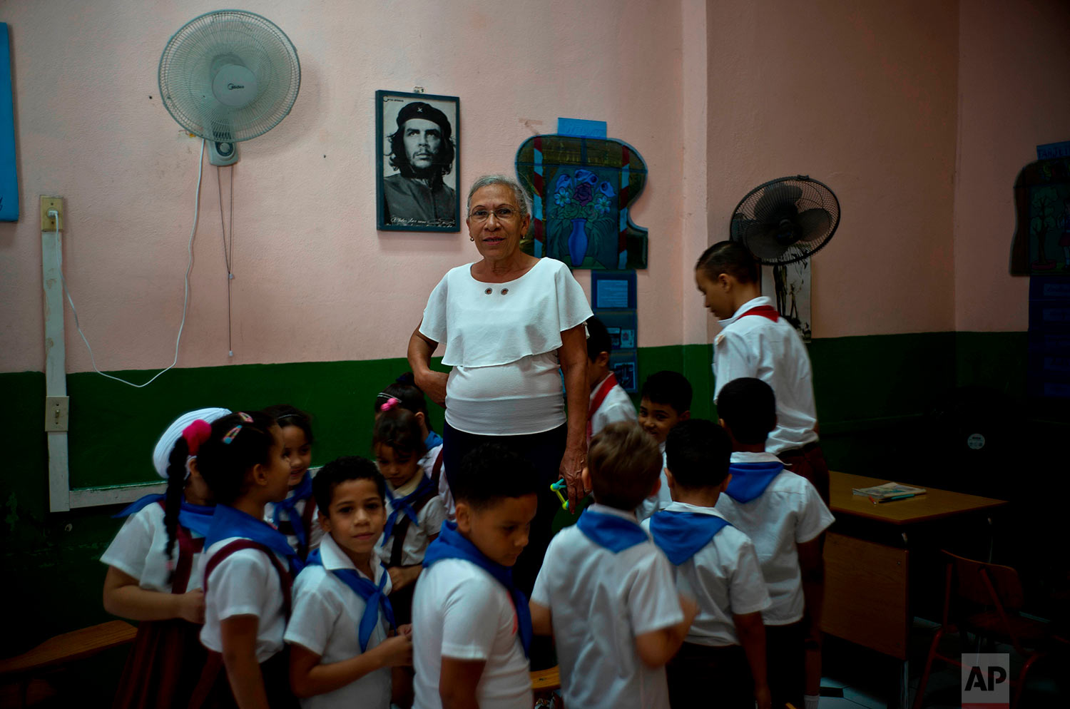 In this April 13, 2018 photo, teacher Luisa Pacheco, 65, poses with her students in Havana, Cuba. Pacheco, who began teaching at the age of 14 in the Sierra Maestra’s rural schools, said she likes education because she wants to train new generations for a good future and achieve what she did. When asked about Raul Castro’s successor, she said “I hope the new president will do what our commander Fidel Castro did,” adding that she wants the U.S. to remove its embargo against Cuba to help improve the economy. (AP Photo/Ramon Espinosa)
