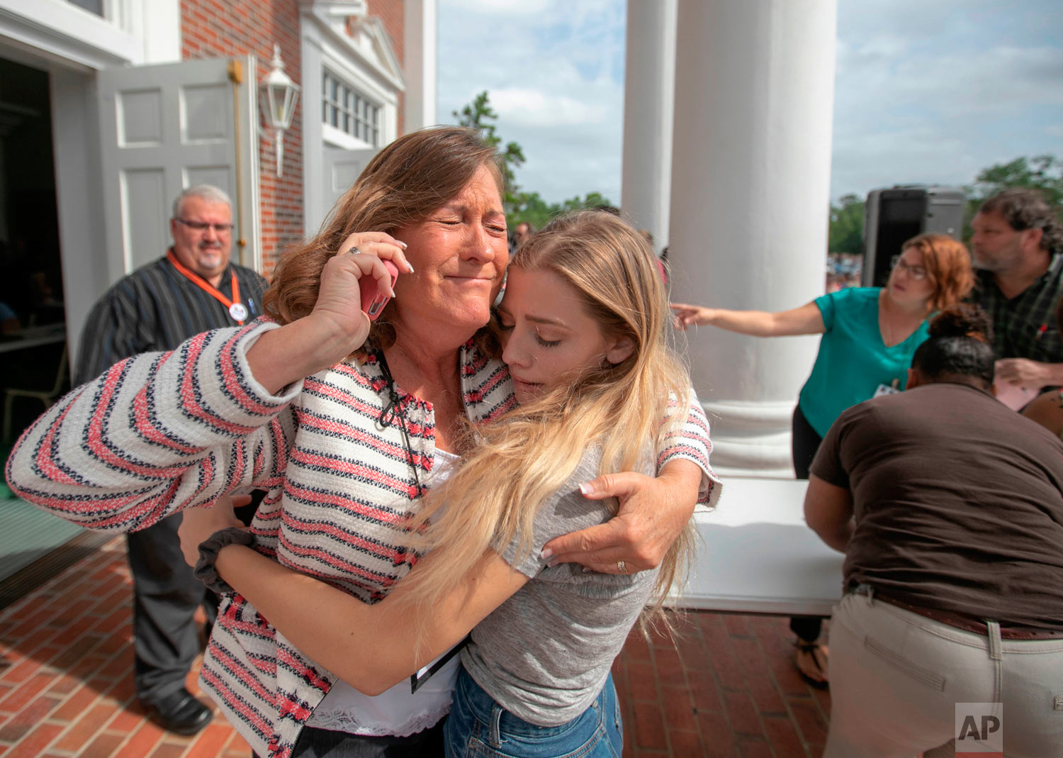 Judge Sarah Ritterhoff Williams embraces family friend student Attie French after finding her in the crowd at First Baptist Church while looking for her own daughter following a shooting at Forest High School, Friday 20, 2018 in Ocala, Fla. One student shot another in the ankle at the high school and a suspect is in custody, authorities said Friday. The injured student was taken to a local hospital for treatment. (Alan Youngblood/Star-Banner via AP)