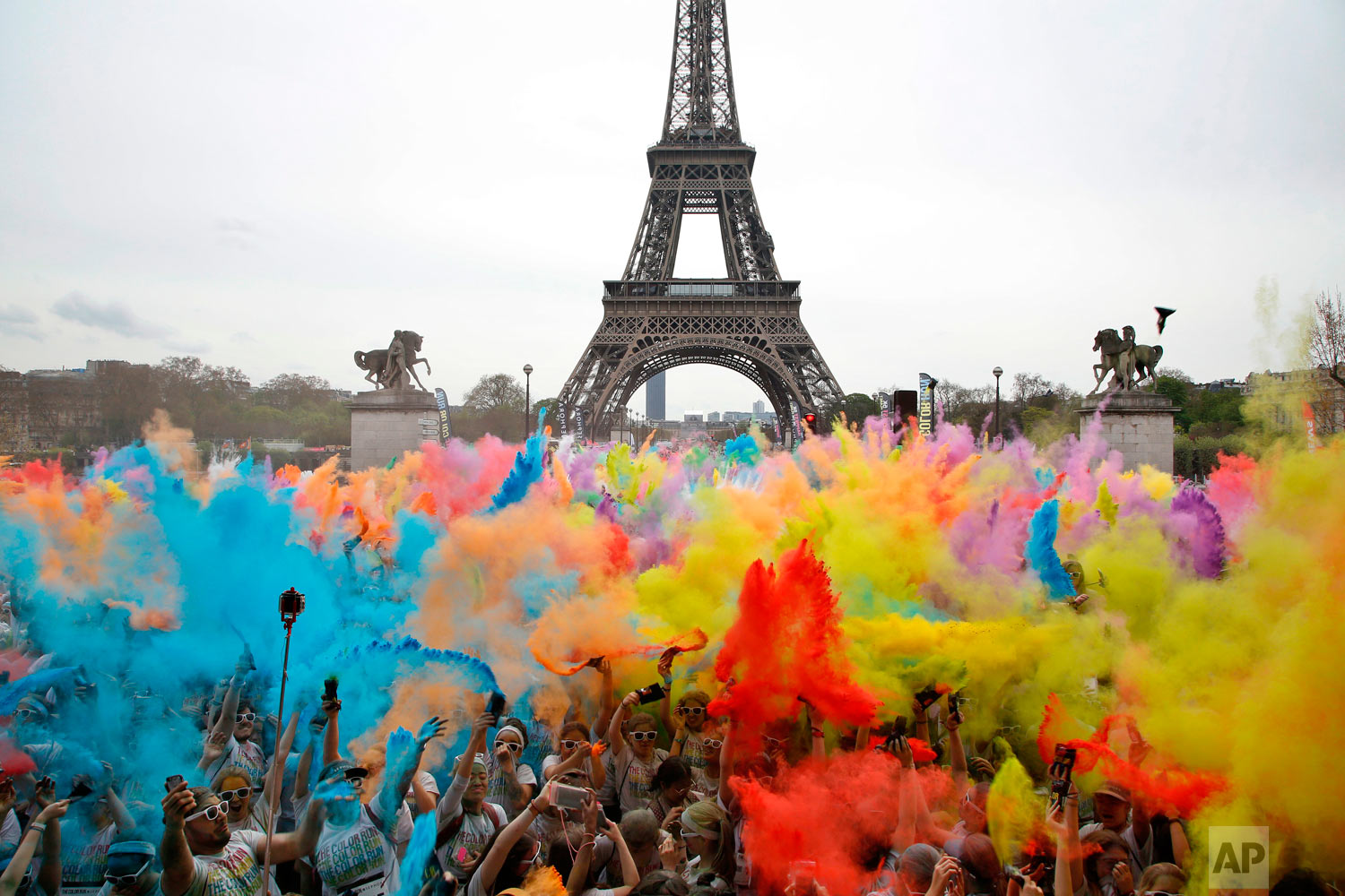  People throw colored powder as they celebrate at the end of the Color Run 2018 race in front of the Eiffel Tower in Paris, Sunday, April 15, 2018. The Color Run is a 5 kilometer (3.1 mile) running event where participants are covered in bright color
