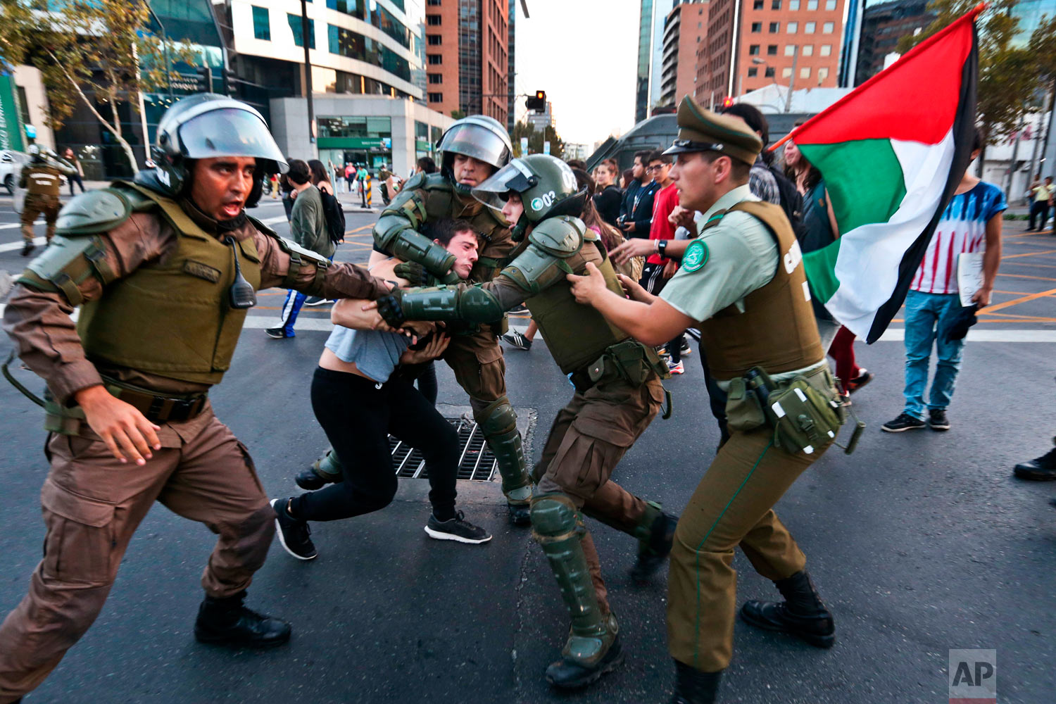 A protester is detained by riot police during a demonstration outside the U.S. embassy in Santiago, Chile, Saturday, April 14, 2018. Supporters of the Chilean Communist party and students took part in an anti-war rally opposing the military strikes in Syria. (AP Photo/Esteban Felix)