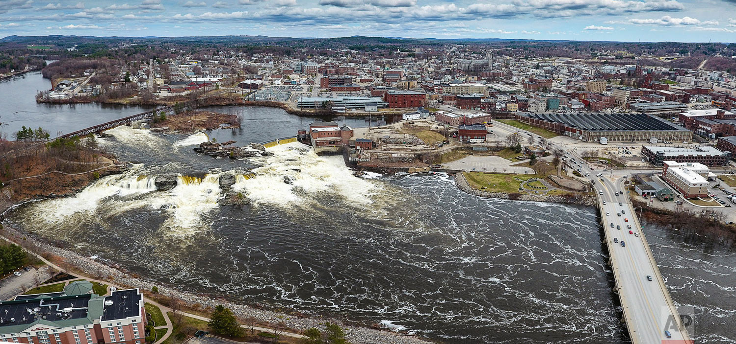  In this aerial photo, Great Falls on the Androscoggin River between Lewiston, rear, and Auburn, Maine, overflows with spring runoff and recent rainfall Friday April 27, 2018. (Russ Dillingham/Sun Journal via AP) 