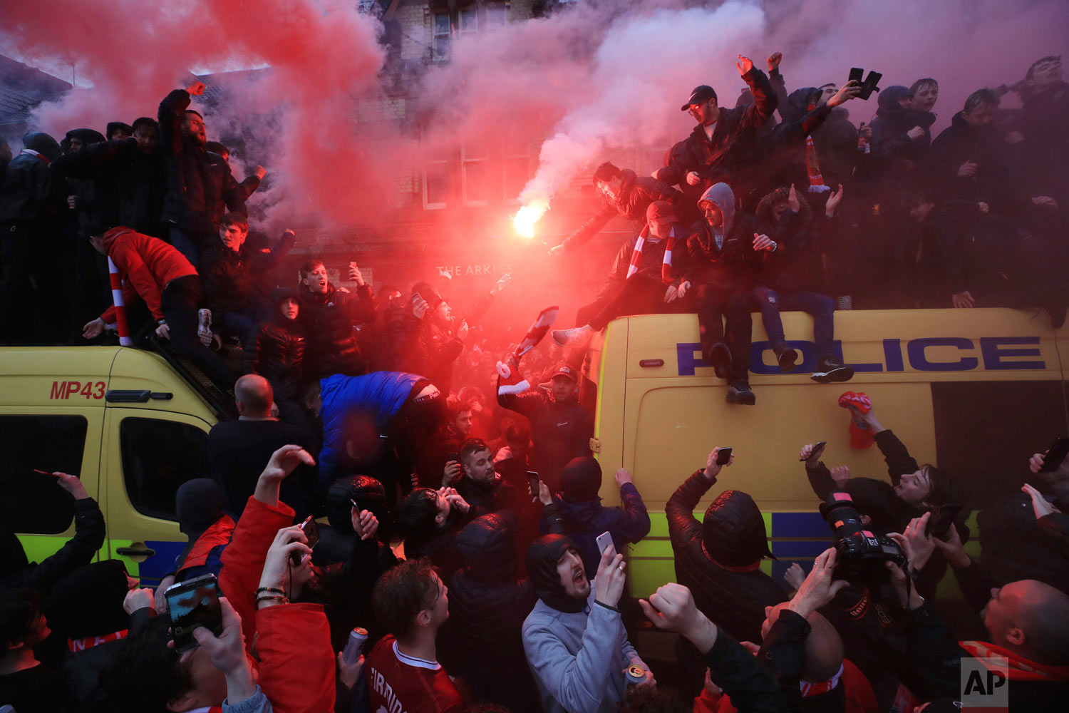  Soccer fans light flares and clamber atop Police vans before their Champions League, Semi Final First Leg soccer match at Anfield in Liverpool, England, Tuesday April 24, 2018. (Peter Byrne/PA via AP) 
