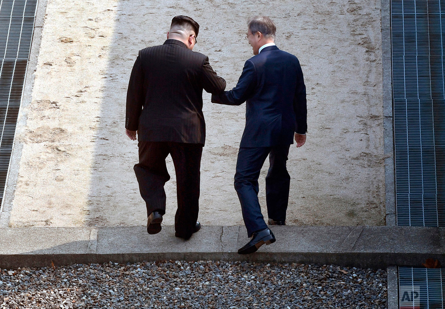  North Korean leader Kim Jong Un, left, and South Korean President Moon Jae-in cross the military demarcation line at the border village of Panmunjom in Demilitarized Zone Friday, April 27, 2018. Their discussions will be expected to focus on whether