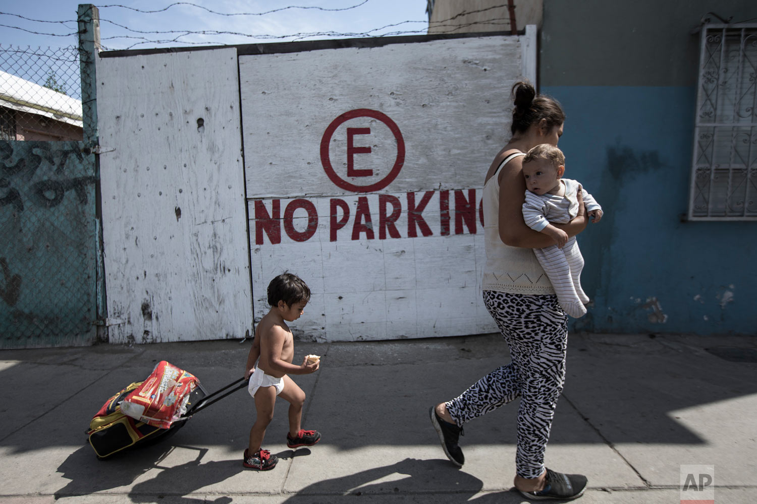  A Honduran migrant who is traveling with a caravan of Central American migrants walks with her two children to a shelter in Tijuana, Mexico, Wednesday, April 25, 2018. The caravan of mainly Central American migrants are planning to request asylum, e