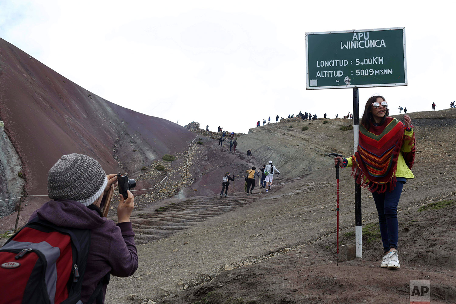  In this March 2, 2018 photo, a tourist poses for a photo at the entrance that leads to Rainbow Mountain, in Pitumarca, Peru. (AP Photo/Martin Mejia) 