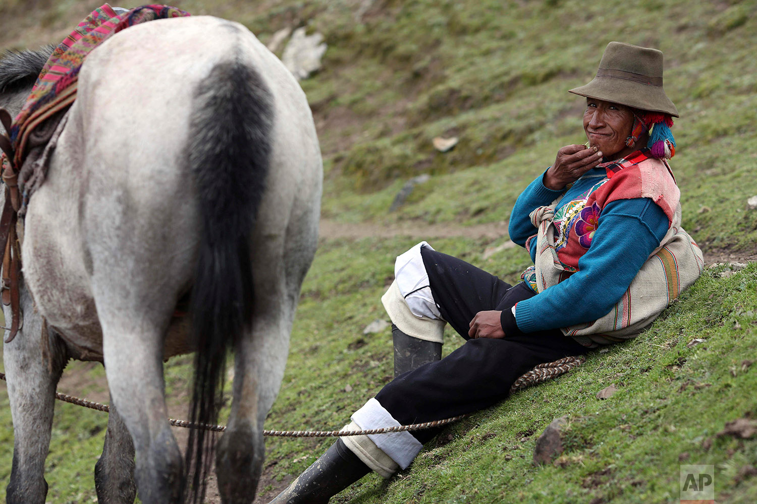  In this March 2, 2018 photo, an Andean muleteer rests during a break from guiding tourists to Rainbow Mountain, in Pitumarca, Peru. (AP Photo/Martin Mejia) 