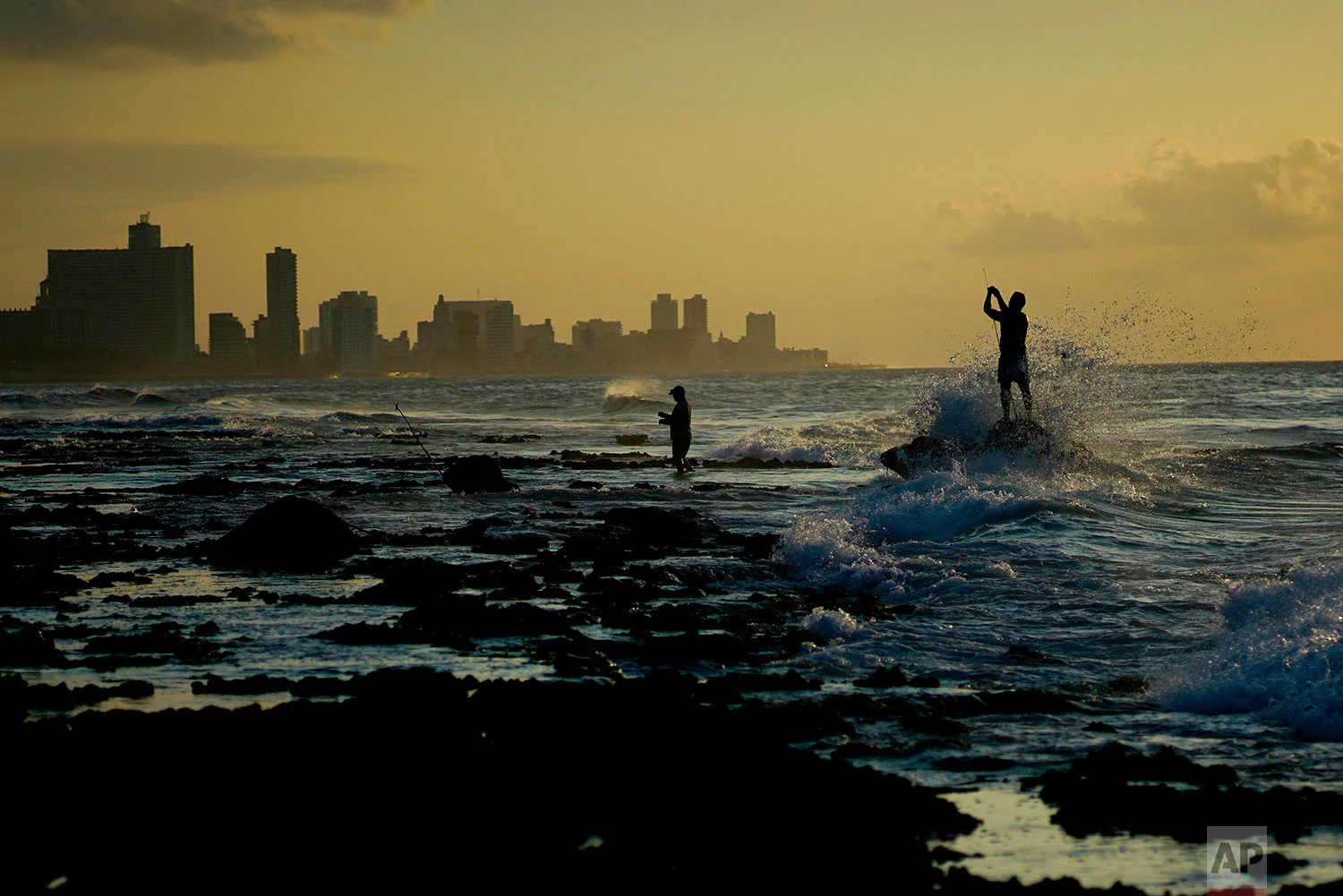 Fishermen prepare their fishing rods on Chivo beach as the sun sets in Havana, Cuba, Thursday, April 12, 2018. (AP Photo/Ramon Espinosa)
