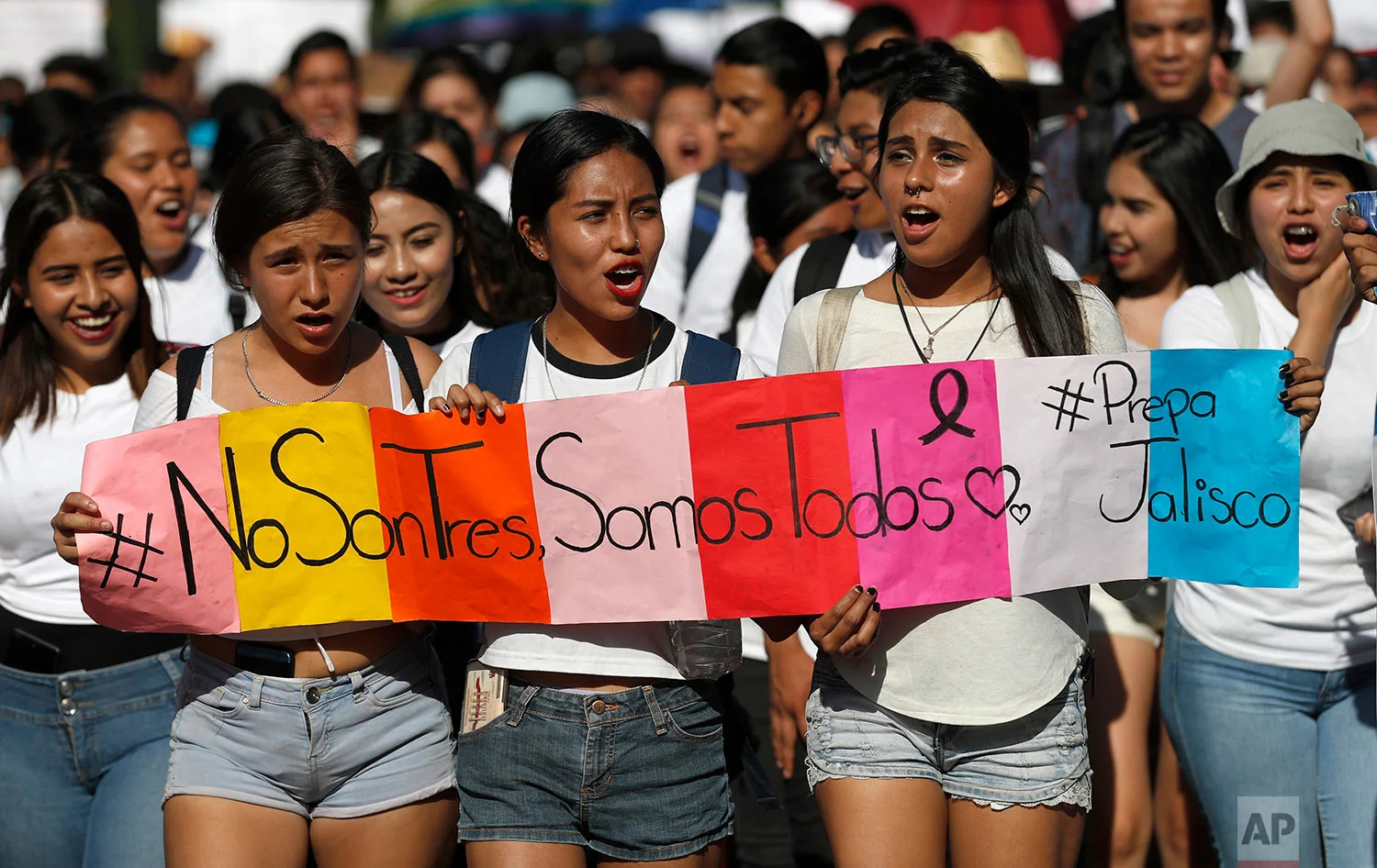 Students hold a sign that reads in Spanish "It's not three, it's all of us" during a protest against the murder of three film students who have become emblematic of Mexico's missing, in Guadalajara, Mexico, Thursday, April 26, 2018. Prosecutors said the three were abducted by the Jalisco New Generation Cartel because they were filming a school project at a house used by the rival Nueva Plaza gang. The students were using the residence because it belonged to one of their aunts. (AP Photo/Eduardo Verdugo)