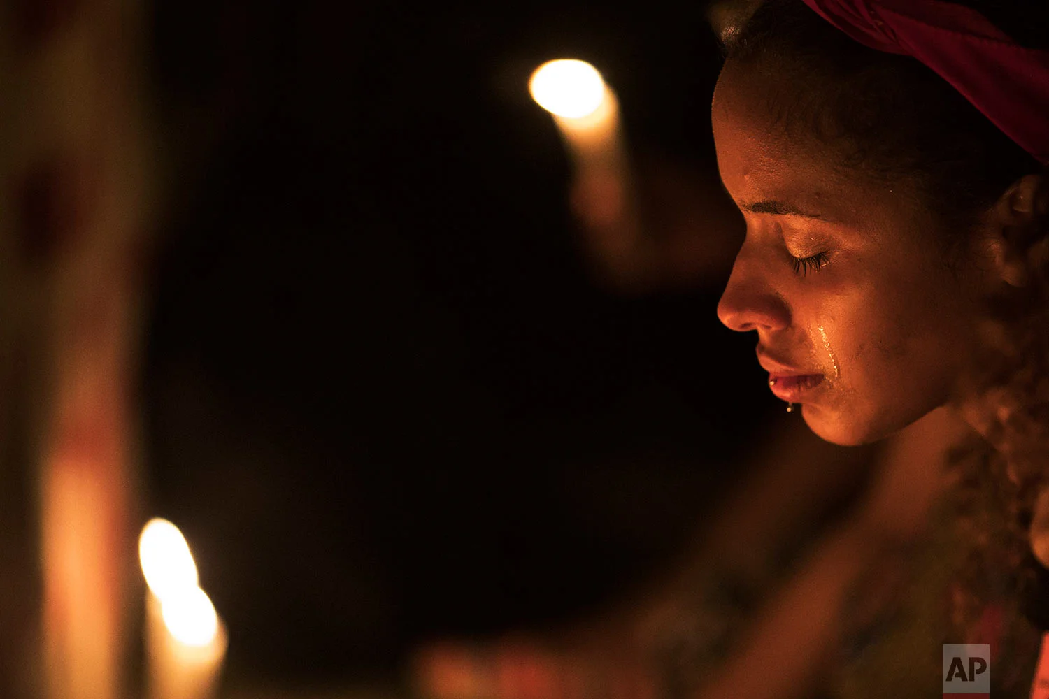A woman cries as she stands on the site where human rights activist and councilwoman Marielle Franco and her driver Anderson Pedro Gomes were killed a month earlier, during a protest in Rio de Janeiro, Brazil, Saturday, April 14, 2018. Thousands of Brazilians took to the streets to demand answers in the death of Franco, whose slaying is seen by her backers as a political assassination. (AP Photo/Leo Correa)