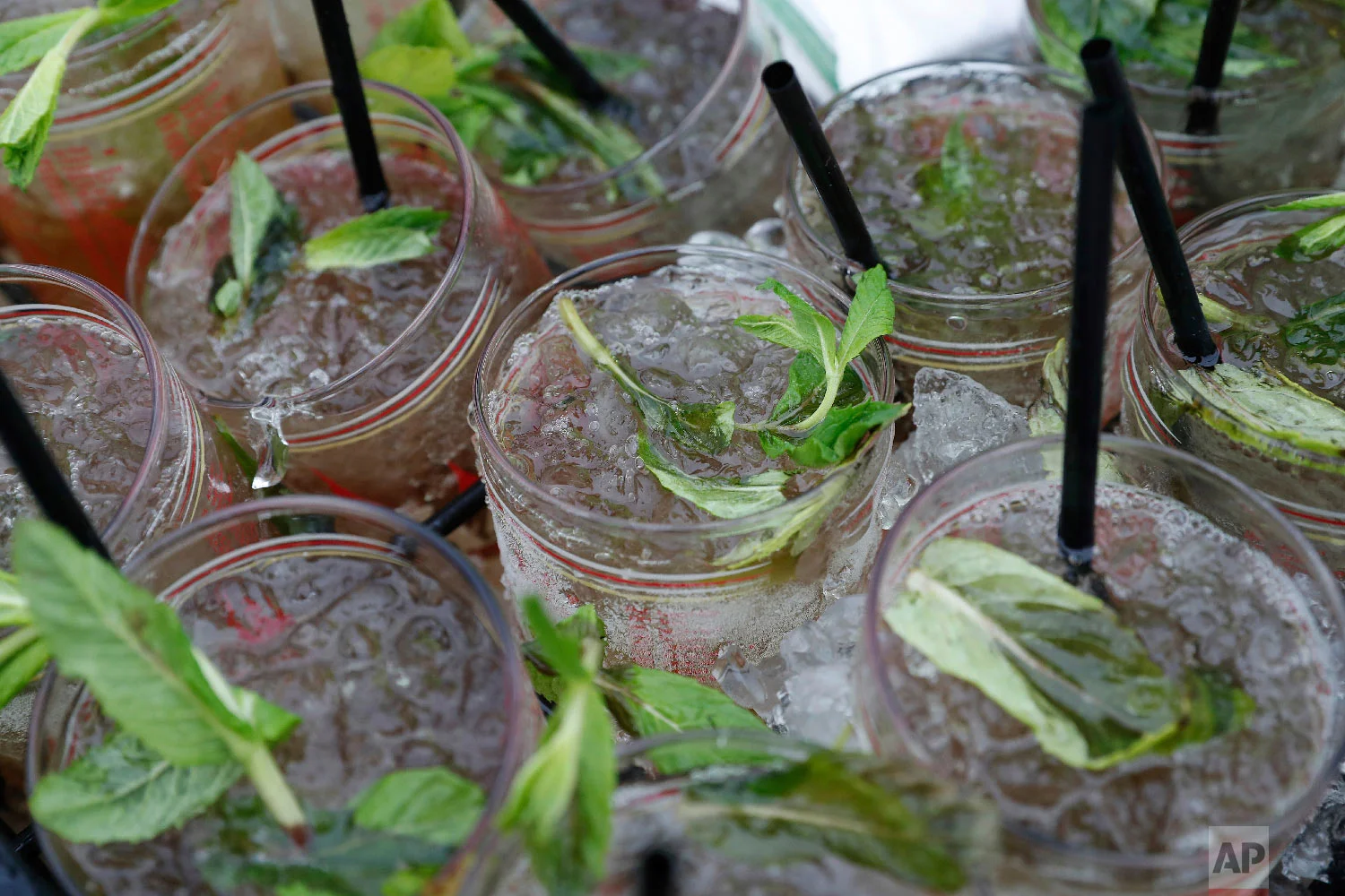 A vendor carries a tray Mint Julep glasses before the 144th running of the Kentucky Derby horse race at Churchill Downs Saturday, May 5, 2018, in Louisville, Ky. (AP Photo/Jeff Roberson)