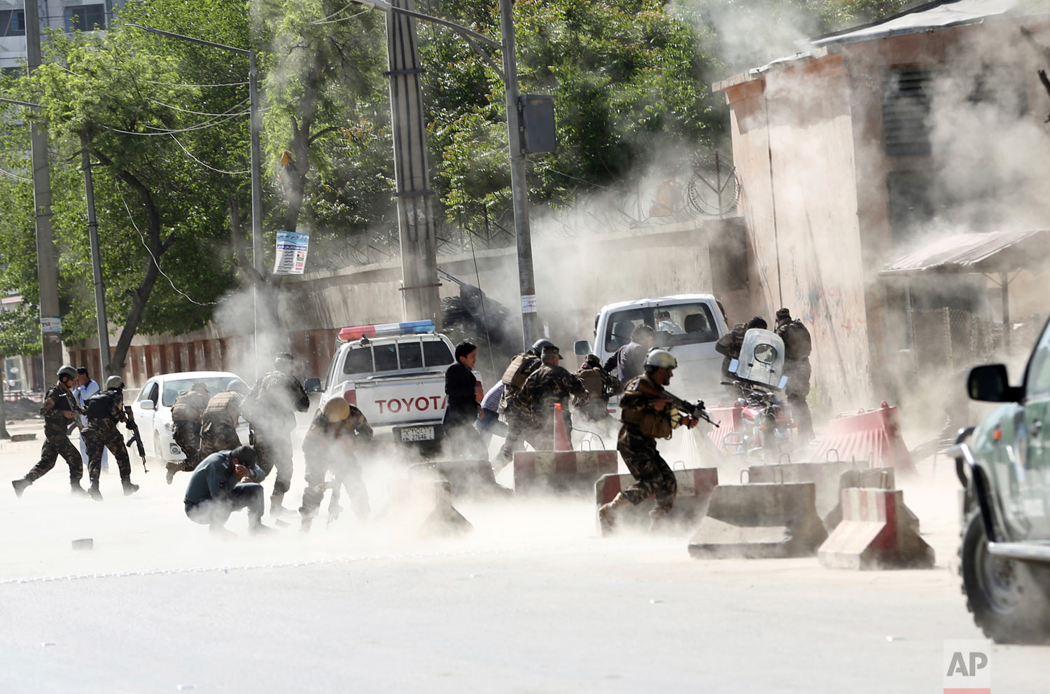 Security forces run from the site of a suicide attack after a second bombing in Kabul, Afghanistan, Monday, April 30, 2018. A coordinated double suicide bombing hit central Kabul on Monday morning. Monday marked the deadliest assault on reporters si