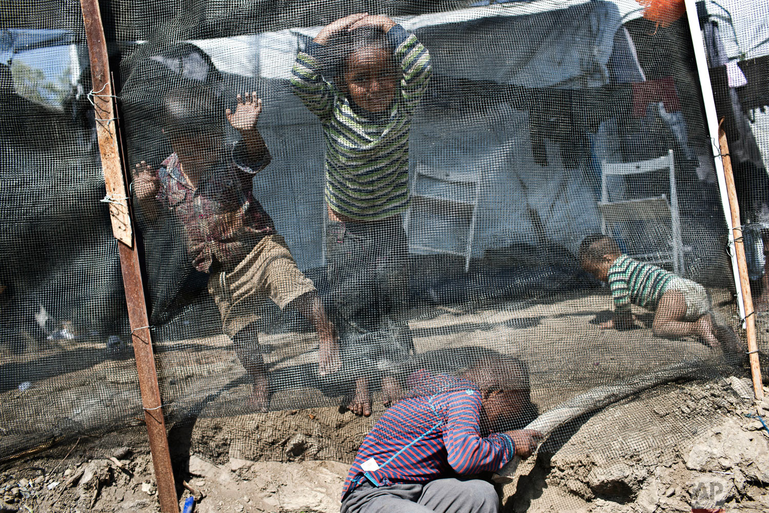 Children play inside the Moria refugee camp on the northeastern Aegean island of Lesbos, Greece, Wednesday, May 2, 2018. Amid protests, the government has promised to drastically reduce overcrowding at island camps over the summer. (AP Photo/Petros