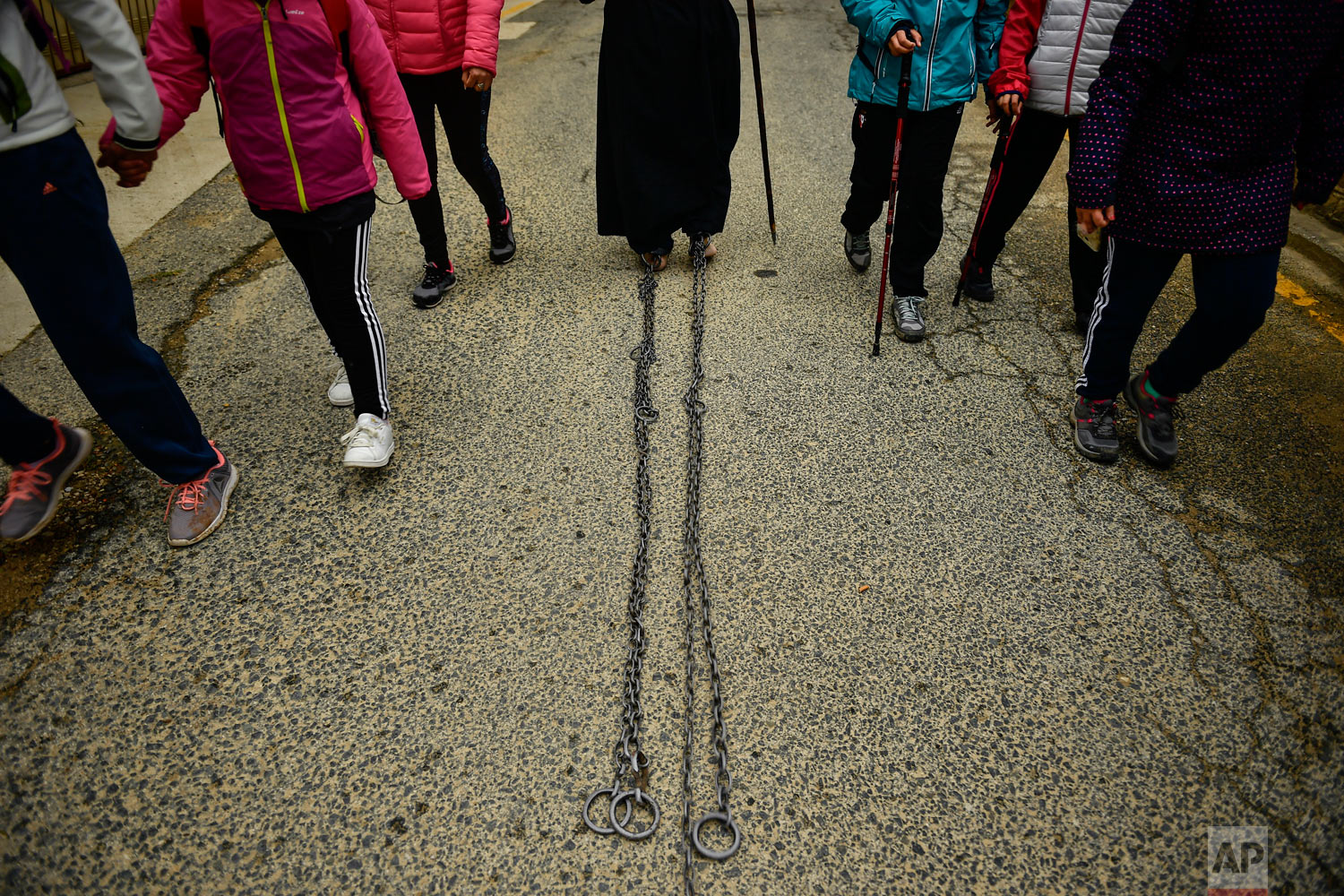A Catholic penitent of the Ujue Virgin walks with chains on his feet during a pilgrimage from Tafalla and other villages to the small town of Ujue, northern Spain, Sunday, April 29, 2018. Every year devotees of Ujue Virgin walk around 25 kilometers