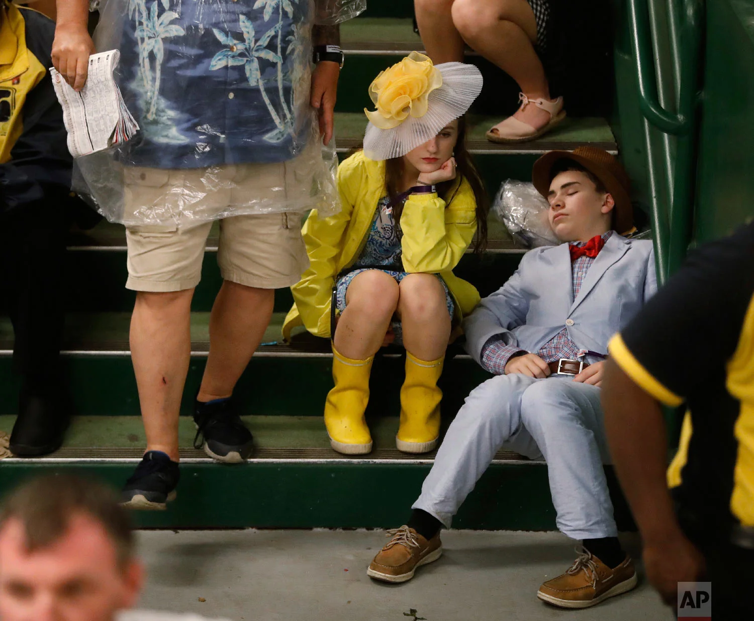 Fans take shelter from the rain before the 144th running of the Kentucky Derby horse race at Churchill Downs Saturday, May 5, 2018, in Louisville, Ky. (AP Photo/John Minchillo)
