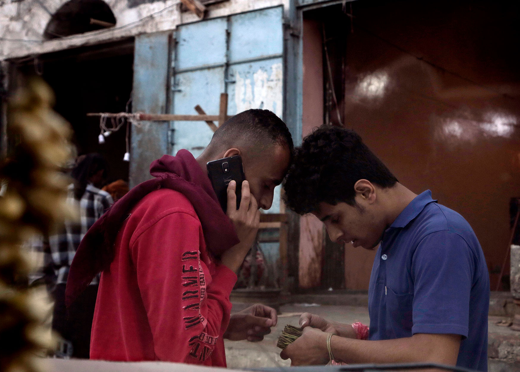 In this Feb. 18, 2018 photo, 21-year old Ahmed Saleh, right, and 30-year-old Mohammed Abu Hassan, look at the Qat they just bought at a market, in Aden, Yemen. (AP Photo/Nariman El-Mofty)