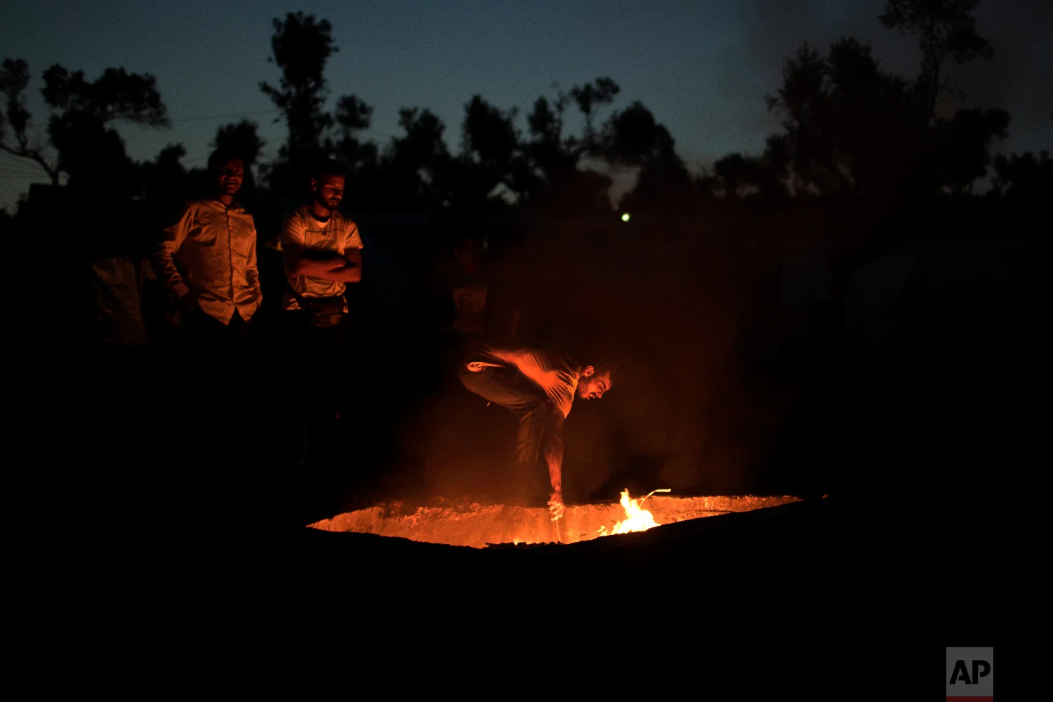 Refugees burn garbage in an old Greek army machine-gun nest, at a makeshift camp outside Moria on the northeastern Aegean island of Lesbos, Greece on Tuesday, May 2, 2018. (AP Photo/Petros Giannakouris)
