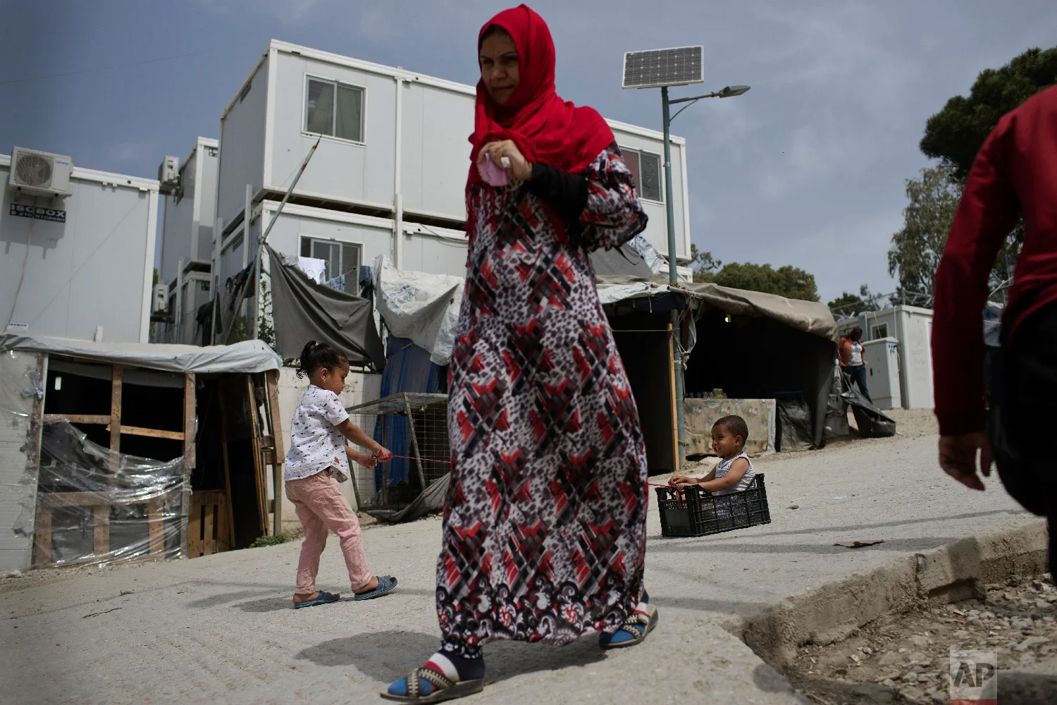 Children play as a woman walks inside the camp of Moria on the northeastern Aegean island of Lesbos, Greece on Friday, May 4, 2018. (AP Photo/Petros Giannakouris)